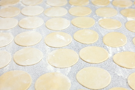 round shape of the dough with flour on the tableの写真素材