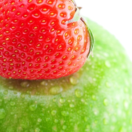 big green apple with water drops and strawberries isolated on whiteの写真素材