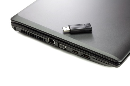 black laptop and flash drive isolated on whiteの写真素材