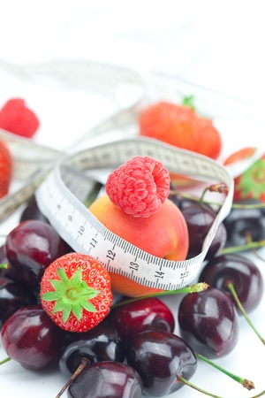 measure tape,strawberry, apricot, cherry and raspberry isolated on whiteの写真素材