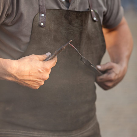 embers, fire, smoke, tools and the hands of a blacksmith