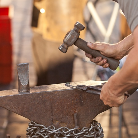 hammer, anvil and the hands of a blacksmithの写真素材