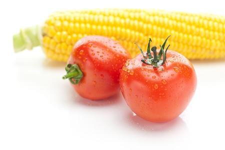 background of ripe yellow corn and tomatoの写真素材