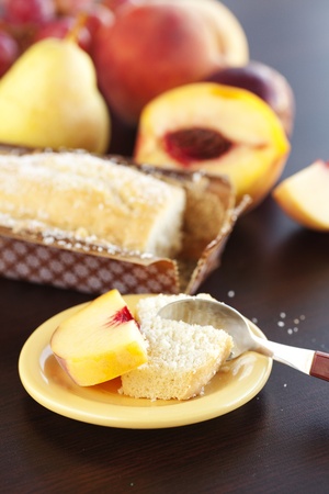 peach, pear, plum, coconut cake,spoon and grapes on a wooden tableの写真素材