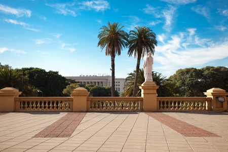 balcony with a statue on a background of palm trees and blue skyの写真素材