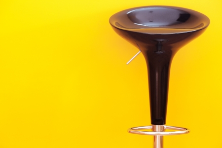 bar chair against a yellow wall in the apartmentの写真素材