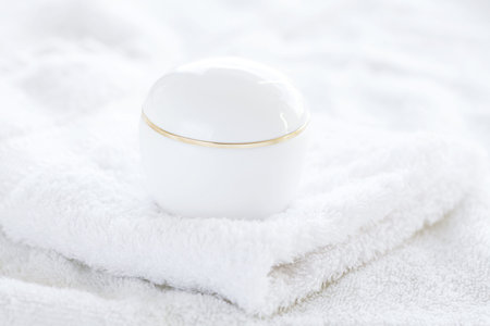 cosmetic containers lying on white towelの写真素材