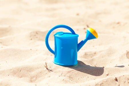 watering can on a background of sandの写真素材