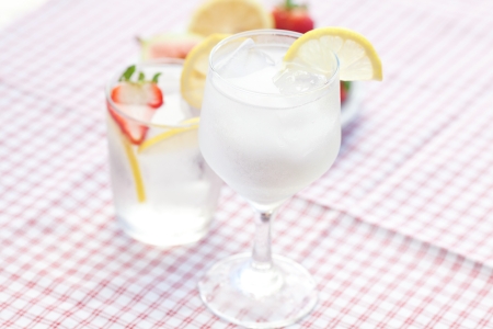 cocktail with ice,lemon, fig and strawberries on a plateの写真素材