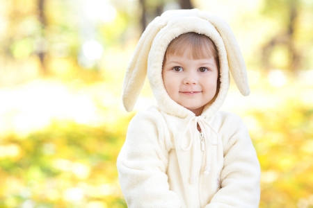 beautiful little girl in costume bunny in the autumn forestの写真素材