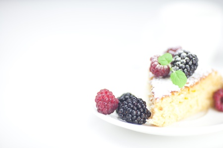 cup, cake, raspberry, blackberry,nuts and mint on a plate on a white backgroundの写真素材