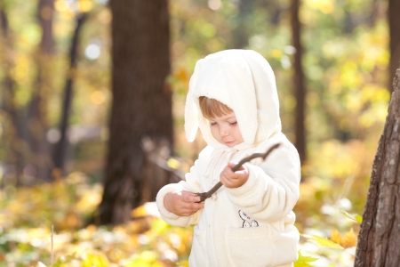 beautiful little girl in costume bunny in the autumn forestの写真素材