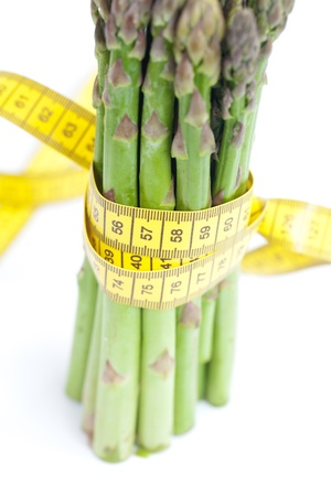 bunch of asparagus tied with measuring tape isolated on whiteの写真素材