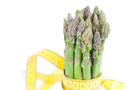 bunch of asparagus tied with measuring tape isolated on whiteの写真素材