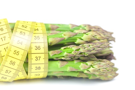 bunch of asparagus tied with measuring tape isolated on whiteの写真素材