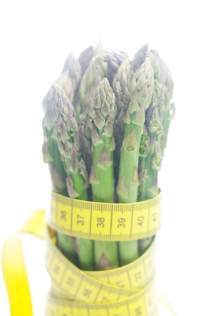 asparagus tied with measuring tape isolated on whiteの写真素材