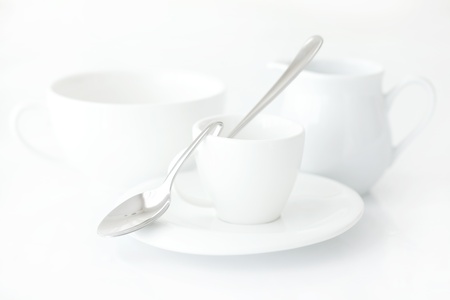 white cup with saucer, milk jug and spoonの写真素材