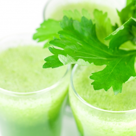 celery and three glasses with celery juice isolated on whiteの写真素材