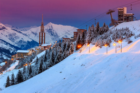 Majestic winter sunrise landscape and ski resort with street lights in French Alps Les Menuires,3...