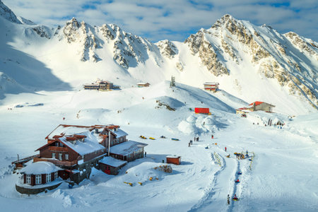 Wonderful winter landscape in Fagaras mountains with famous frozen Balea lake and wooden houses,...