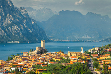 Amazing summer travel destination, famous Garda lake with high mountains in background and wonderful Malcesine mediterranean tourist resort, Italy, Europeの写真素材