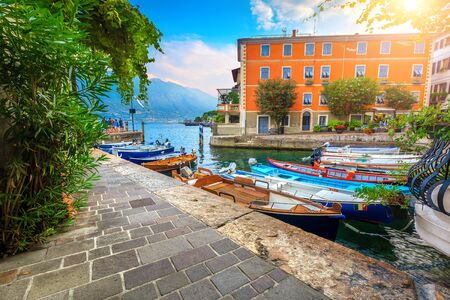 Stunning summer landscape, wooden fishing boats and colorful mediterranean buildings in spectacular harbor, Limone sul Garda tourist resort, lake Garda, Lombardy region, Italy, Europeのeditorial素材