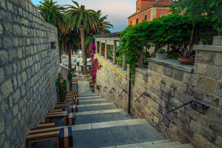 Cute narrow street with street cafe decorated mediterranean bougainvillea flowers. Wonderful...