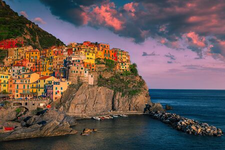Magnificent travel and touristic resort. Charming touristic village with colorful houses on the cliffs at sunset, Manarola, Cinque Terre, Liguria, Italy, Europeの写真素材