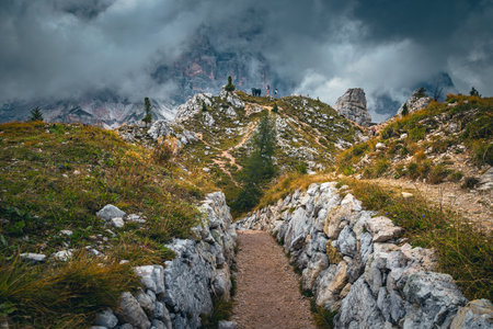 Spactacular rocky hiking trail and misty mountains near Cinque Torri cliffs, Dolomites, Italy, Europeの写真素材