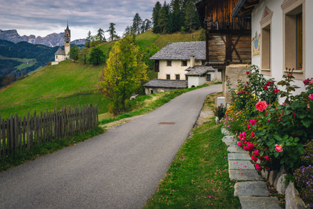 Spectacular alpine street view with famous chapel of St Barbara and traditional houses on the slope...