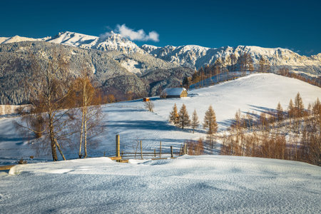 Fabulous winter scenery with snow covered slopes and spectacular high mountains in background,...