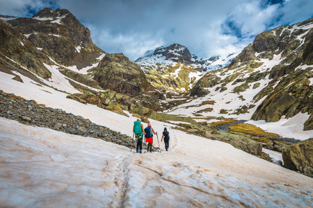 Picturesque scenery with hikers on the snowy trail, near Lake Trecolpas in the Mercantour National Park, Alpes Maritimes, France, Europeの写真素材