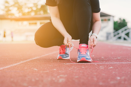 Young lady running on road closeup on shoe., at time sunset.の写真素材