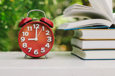 Education concept, Book and Clock with green blur background.,Books stacking.の写真素材