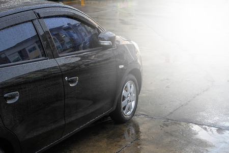 Raindrops on a car surface,Car wash, black car in automatic car washの写真素材