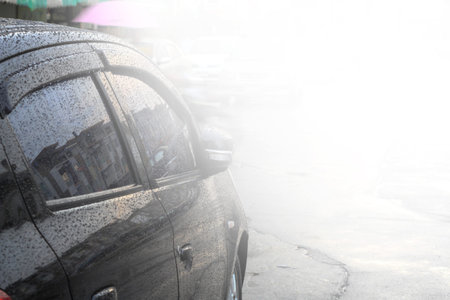 Raindrops on a car surface,Car wash, black car in automatic car washの写真素材