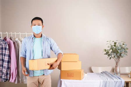 Asian man video live streaming sell shirt e commerce store or blogger live broadcasting selling shirt by smartphone and sharing on social media by at homeの写真素材