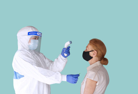 Disease control experts  use an Infrared thermometer equipment to check the temperature on the...
