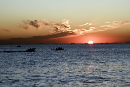 A beautiful sunset with calm ocean setting off the red sunの写真素材