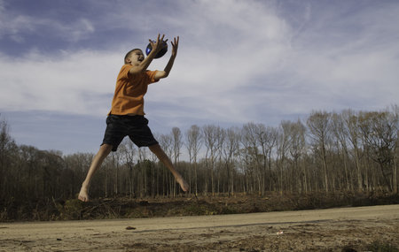 Young male outdoors being active playing ball