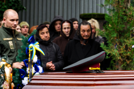 Uzhhorod, Ukraine - 2016. October 12: Relatives and friends stand near the coffin of the ukrainian soldier who heroically died in the ATO zone  during a funeral at the Hill of Glory.のeditorial素材