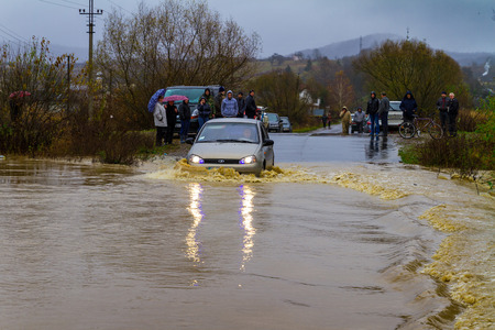 Zarichevo, Ukraine - November 7, 2016: A car drives through a flooded road leading to the village. Over the weekend, fell out in Transcarpathia two monthly rainfall.のeditorial素材