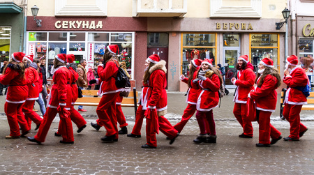 Uzhgorod, Ukraine - December 19, 2016: Participants in the parade of Saint Nicholas assistants marching in the city center. On this day, people in red and white caps greeted passers-by, handing out  tones of sweets and as usual, lit the lights on the Chriのeditorial素材