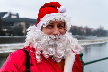 Uzhgorod, Ukraine - December 19, 2016: Member of the parade of Saint Nicholas assistants. On this day, people in red and white caps greeted passers-by, handing out tones of sweets and as usual, lit the lights on the Christmas tree in the central square. Tのeditorial素材