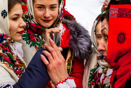 Uzhgorod, Ukraine - January 15, 2017: Members of folklore groups use the mobile phone as a mirror during the seventh ethnic festival Christmas Carols in the old village. During the festival, visitors can familiarize with a variety of Christmas customs, caのeditorial素材