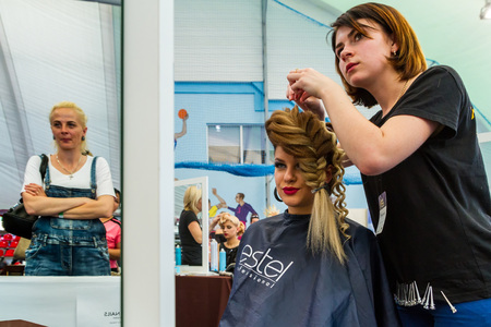 Uzhhorod, Ukraine - May 19, 2017: Hairdresser makes wedding hairstyle during the International Beauty Industry Competition Royal Buauty Carpathian Cup 2017.のeditorial素材