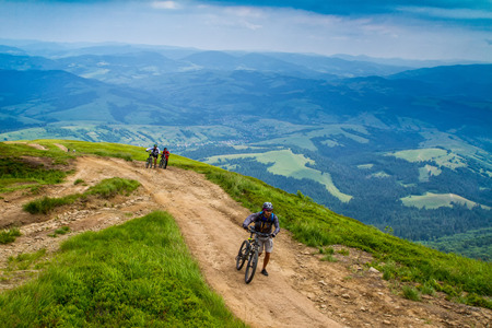 Pylypets, Ukraine - June 25, 2017: Cyclists pushing bicycles during a climb to the peak of Mount Hymba in the Carpathians near the village of Pylypets.のeditorial素材
