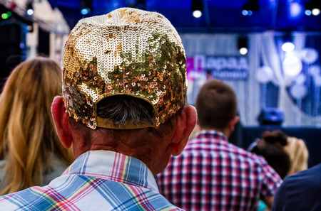 Uzhgorod, Ukraine - July 9, 2017: Senior man in a glamorous cap with rhinestones looks concert.のeditorial素材