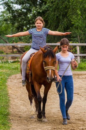 Vynohradiv, Ukraine - July 12, 2017:  Girls learn horseback riding during a vacation in the summer children's equestrian sports camp.のeditorial素材