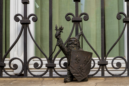 Wroclaw, Silesia, Poland - July 25, 2017: Miniature bronze figure of a gnome with a shield on the window sill of a house in the city center.のeditorial素材